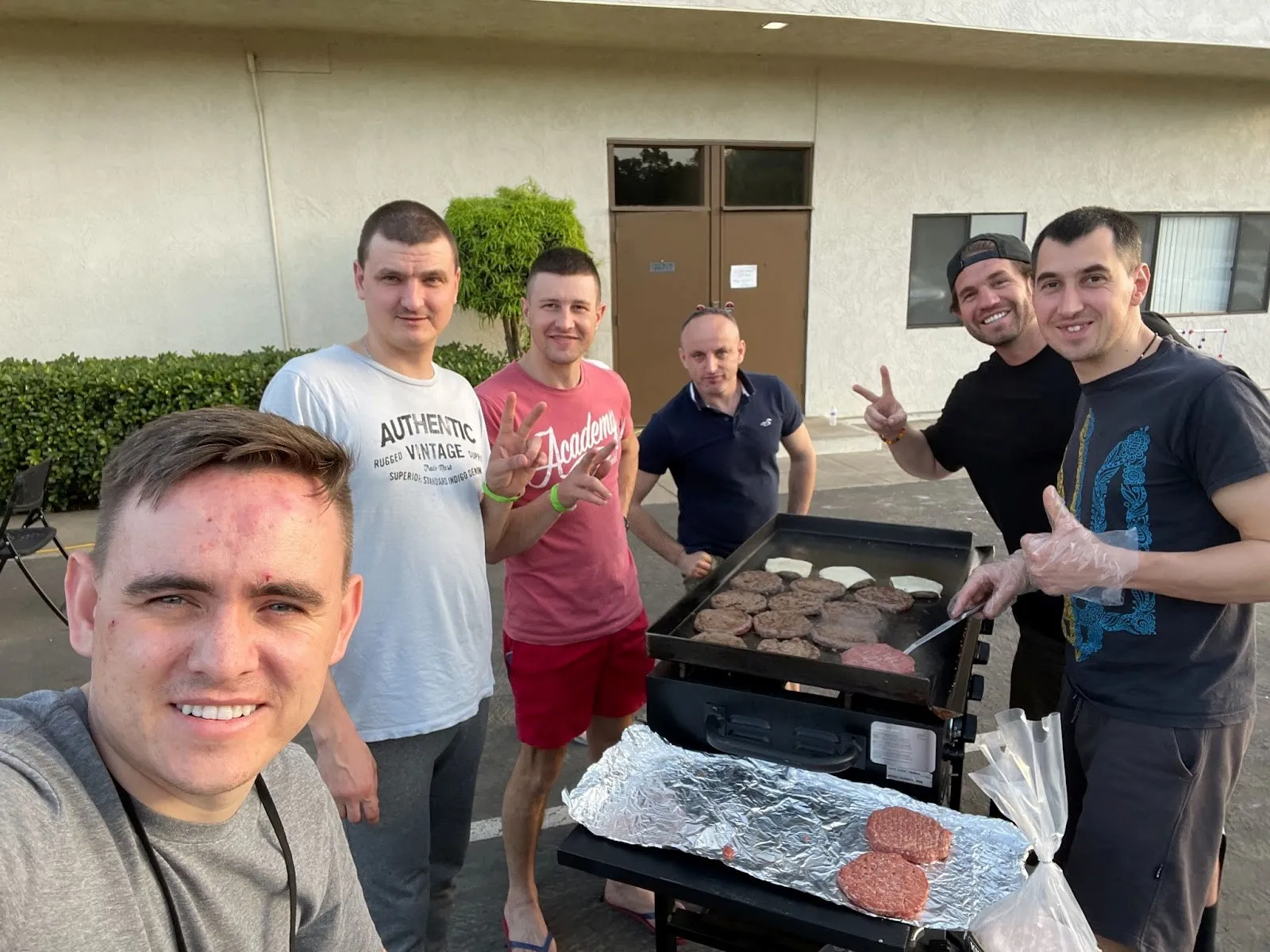 Ukrainian refugees with chef Milosh (right) and volunteers grilling burgers for Spring Valley Community Church refugees.
